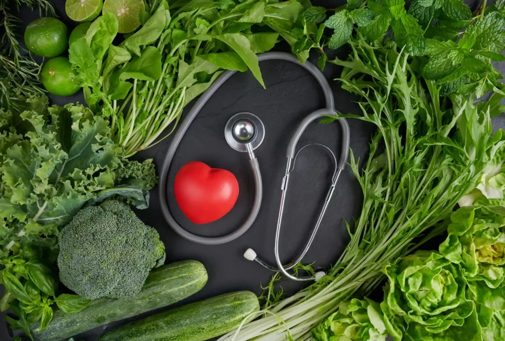 Veganství a zdraví srdce s čerstvou zeleninou, stetoskopem a symbolem srdce jako podpora kardiovaskulárního zdraví u veganské stravy.