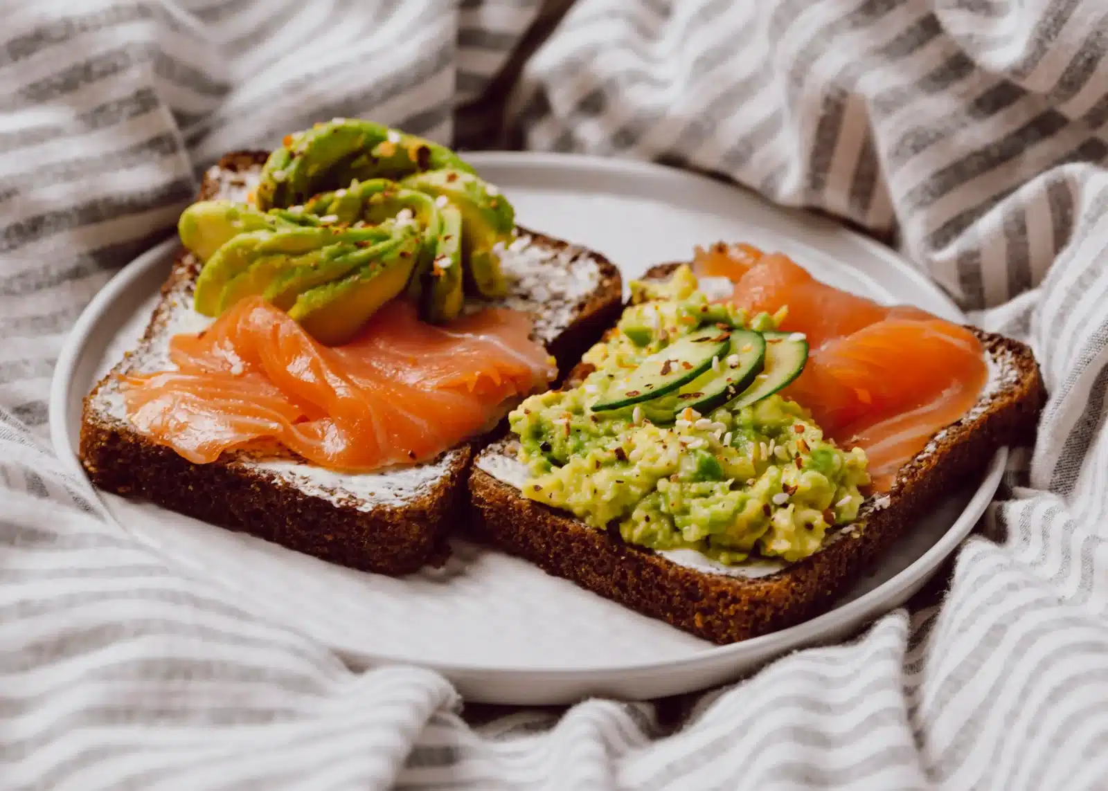 Avokádový toast se sýrem cottage a uzeným lososem – varianta s plátky avokáda i s avokádovou pomazánkou.