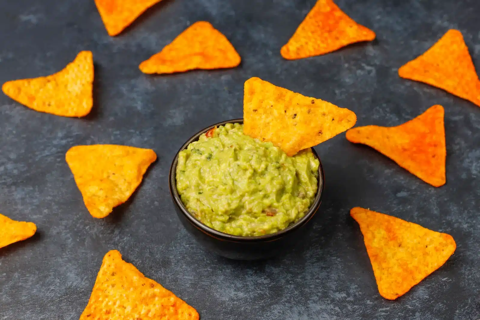 Recept z avokáda – čerstvé guacamole v misce podávané s nachos chipsy.